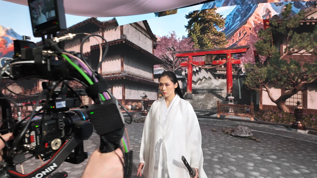 On set: a camera operator and an actress in front of the LED wall showing a Japanese town