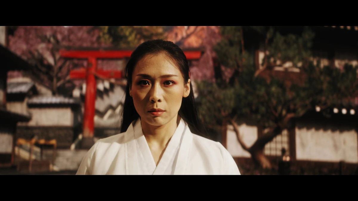 Shot: a woman in a white kimono in front of a Japanese torii gate