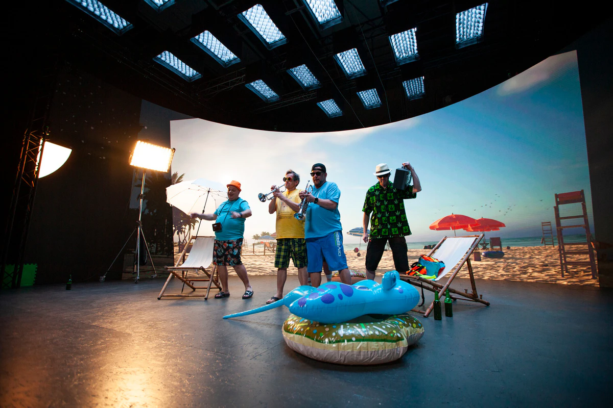 On set: a band in front of a beach shown on the LED wall