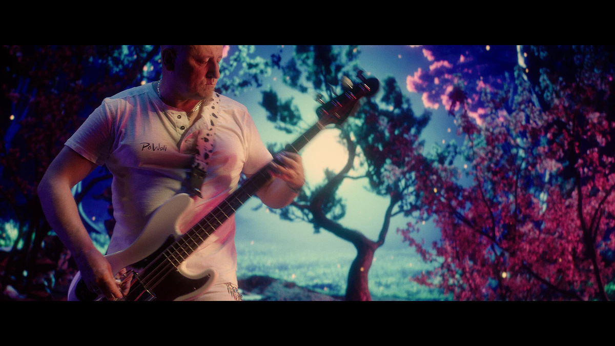 Music video shot: a guitarist under a blossoming tree