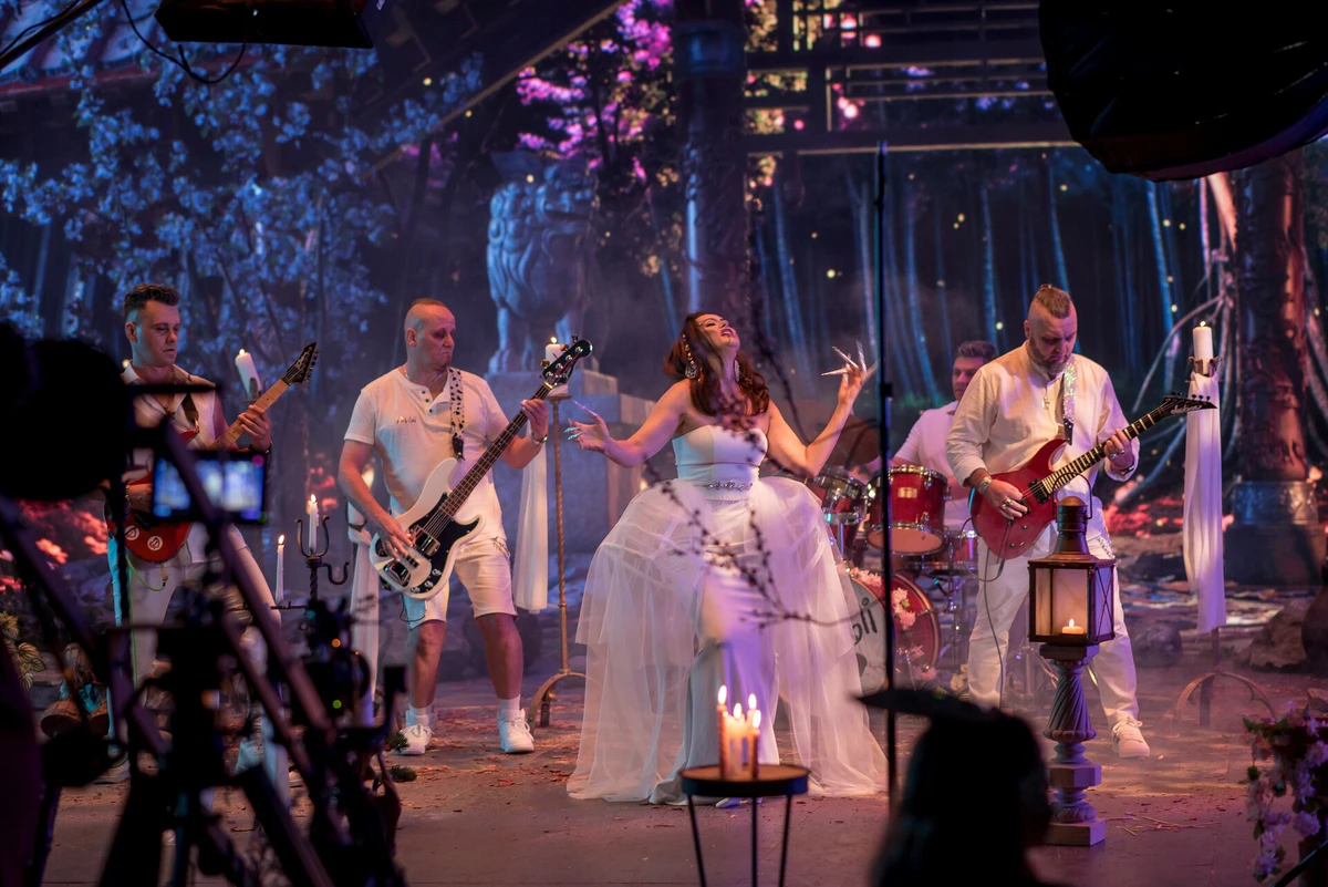 On set: a band on stage with a tree shown on the LED wall