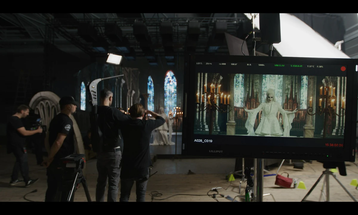 On set: the crew at a preview monitor in front of a gothic set