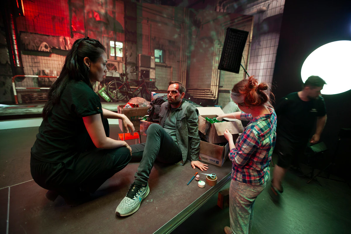 On set: actors and crew with a city set