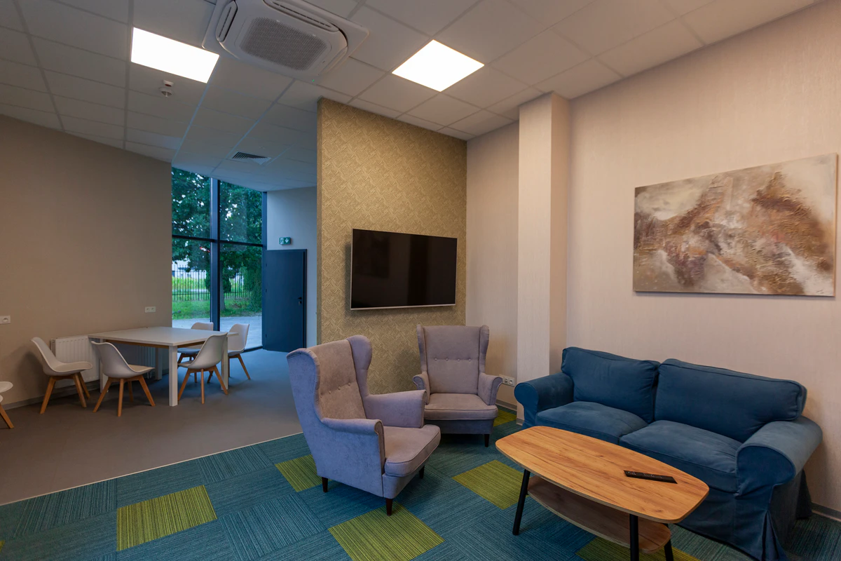 Lounge area with a sofa, armchairs and a TV